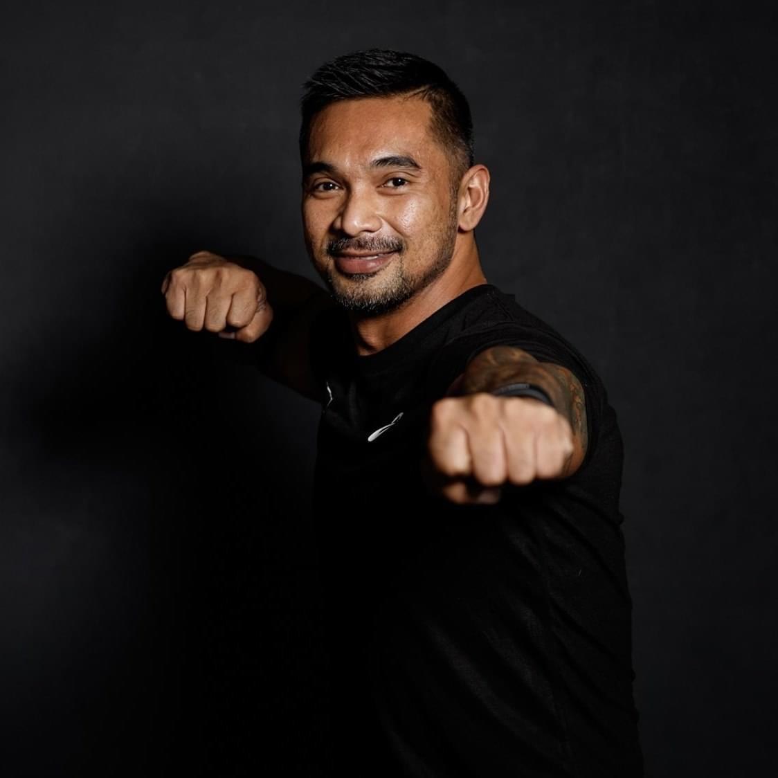 Ron Garcia in a boxing guard, photographed against a dark studio backdrop
